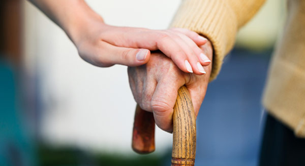 A caregiver comforts a man with a cane