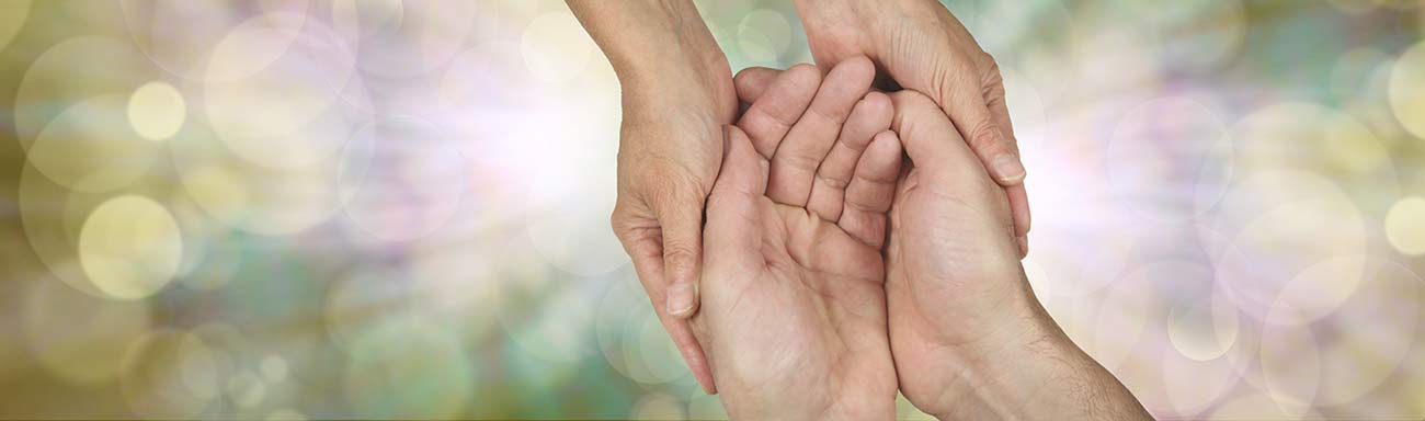 A caregiver embraces the hands of an individual with dementia. Alzheimer's Disease Caregiver Support Program.